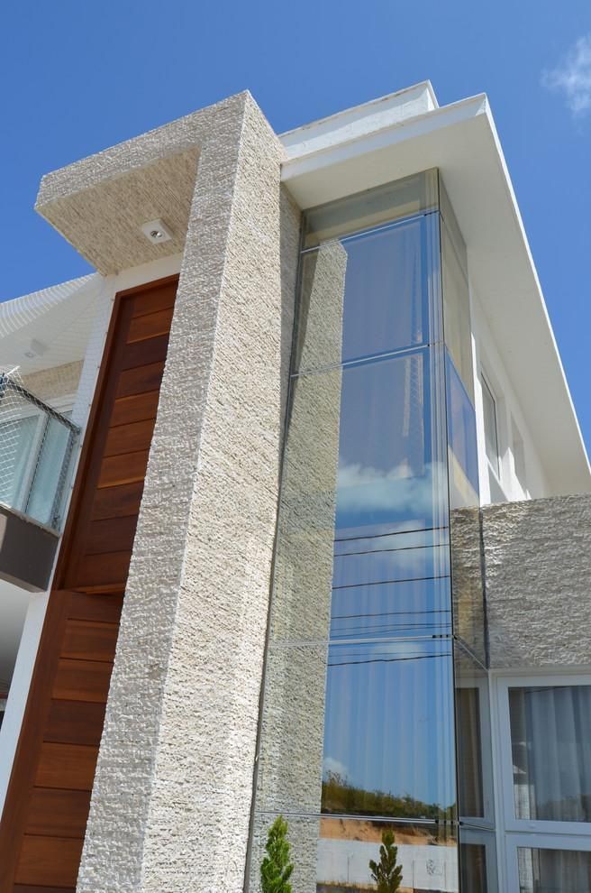 Fachada contemporânea revestida com pedra natural clara